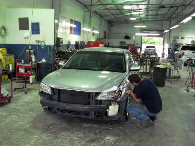 Silver sedan undergoing collision repair